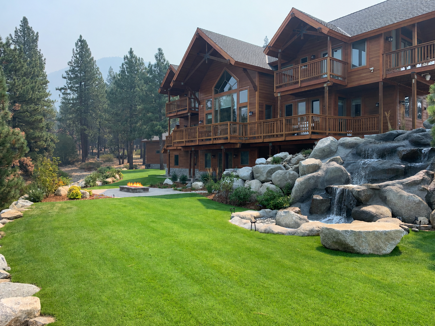 Tahoe landscape project with lawn, boulder waterfall, mountain home, and pine forest setting