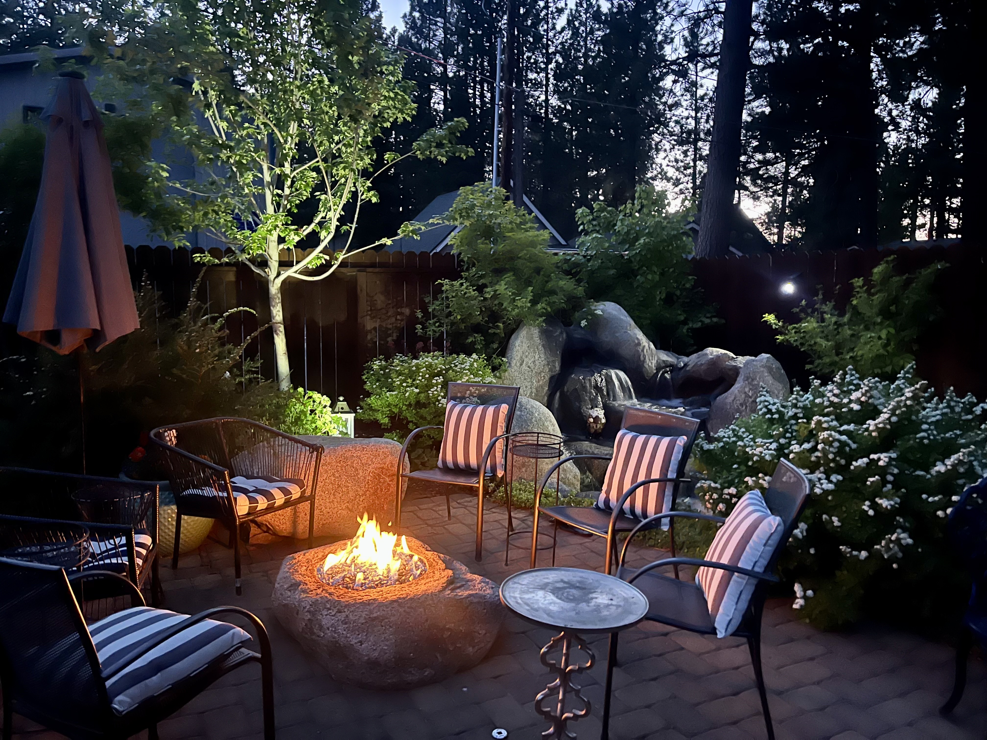 Fire feature, water feature, lighting, seating, and private backyard atmosphere